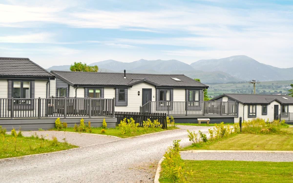 The lodges at Lillyhall Lodge Retreat with the Lakeland fells behind