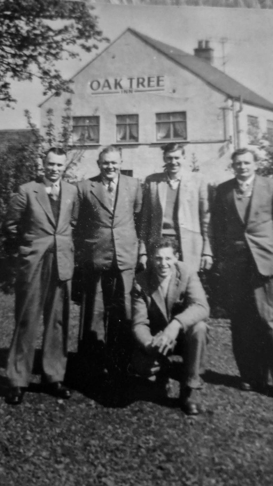 Black and white photograph of five men stood outside the Oak Tree Inn at Winscales, the building that is now Oily's